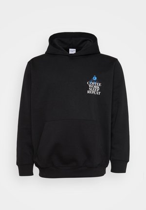 Schwarzer Kapuzenpullover mit einer Fronttasche. Mit weißem und blauem Text: "KAFFEE ARBEITEN SCHLAFEN WIEDERHOLEN" über einer Grafik einer sitzenden Person.