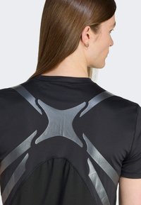 Zwarte sportshirt met een grijs geometrisch ontwerp op de achterkant. Gemaakt van gladde, rekbare stof met een hoge halslijn.