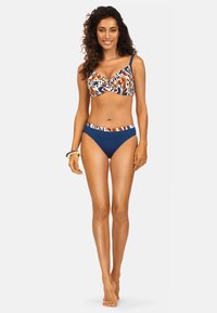 Zestaw bikini z kolorowym braletem w wzory, z detalem w formie skrętu oraz granatowymi, wysokimi majtkami. Gładki materiał z regulowanymi ramiączkami.