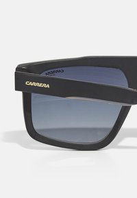 Must musta prillid gradient objektiividega. Omab julget, nurkadega disaini ja kuldset "CARRERA" logo küljel. UV-kaitse on märgitud.