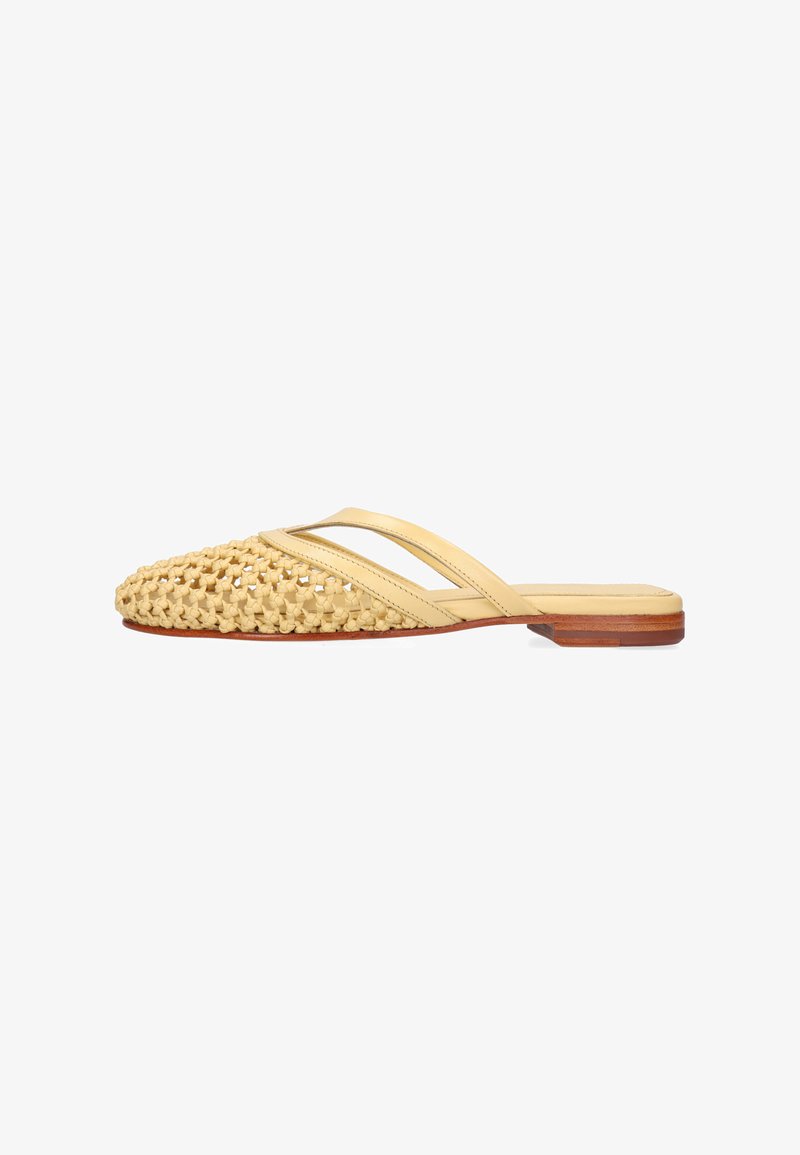 Mule beige tressée à bout pointu avec deux fines brides et un petit talon en bois, vue de profil sur fond blanc.