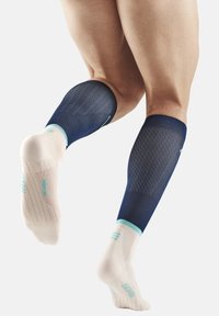 Kompressionssocken mit einem marineblauen oberen Abschnitt und einem hellbeigen, strukturierten Fuß. Sie verfügen über ein atmungsaktives Mesh-Design und türkisfarbene Akzente.
