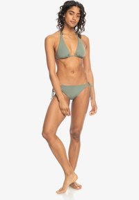Green bikini set featuring a triangle top with adjustable straps and a tie-side bottom. Smooth texture, minimalistic design, and fitted shape.