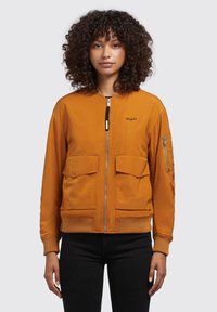 Orange Bomberjacke mit Reißverschluss, gerippten Bündchen, zwei großen Fronttaschen und einer zusätzlichen Taschen am Ärmel. Glatte Stofftextur.