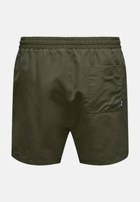 Bañador verde en una tela ligera, con cinturilla elástica y un bolsillo trasero con solapa. Textura suave.