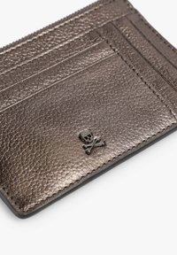 Tarjetero de cuero gris texturizado con múltiples ranuras y un adorno negro de calavera y huesos cruzados.