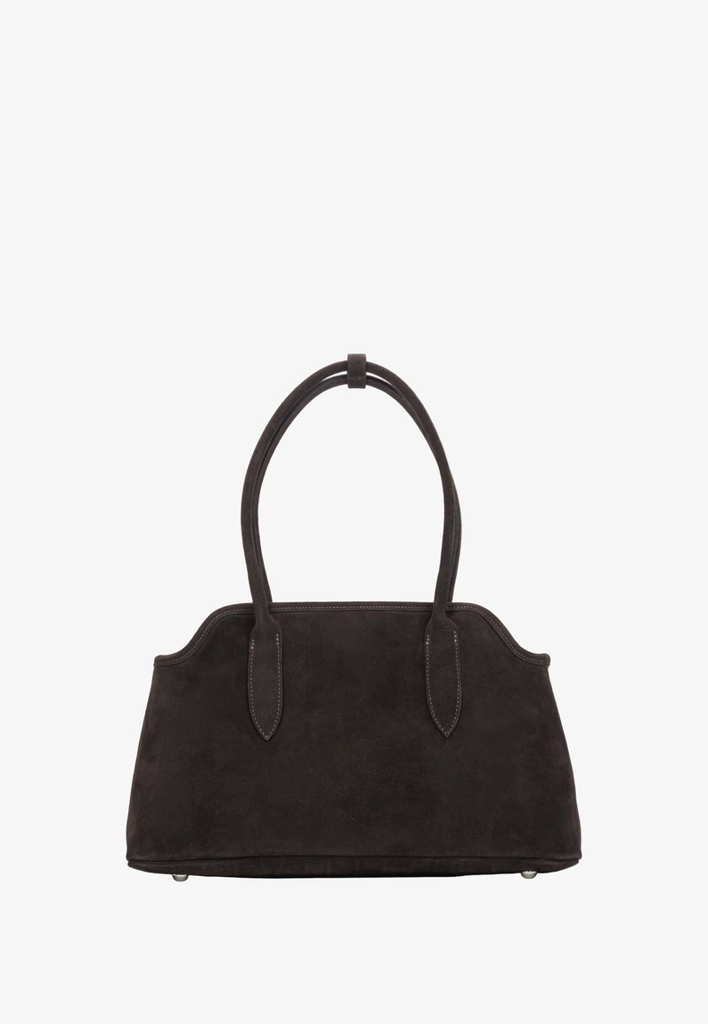 Torba z ciemnobrązowego zamszu o wyraźnie zarysowanym kształcie, wyposażona w dwie zaokrąglone rączki oraz subtelne przeszycia. Dno wyposażone w nóżki zapewniające stabilność.