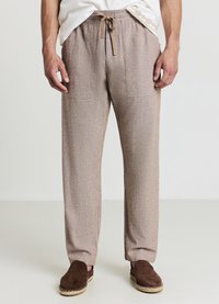 Hellbraune Jogginghosen aus strukturiertem Stoff, ausgestattet mit einem elastischen Bund mit Kordelzug und zwei Vordertaschen.