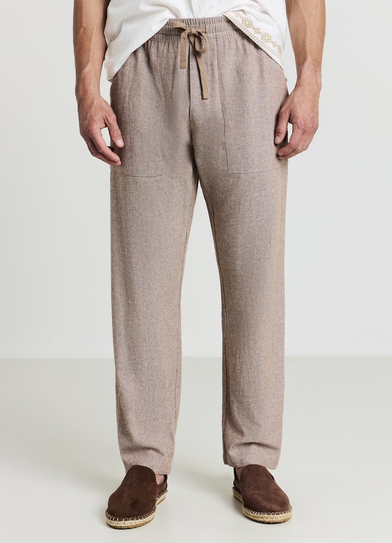 Hellbraune Jogginghosen aus strukturiertem Stoff, ausgestattet mit einem elastischen Bund mit Kordelzug und zwei Vordertaschen.