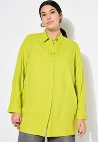 Limoengroene button-up shirt van gestructureerde stof, met twee borstzakken, lange mouwen en een losse pasvorm. Voorzien van een klassieke kraag en knoopdetails.