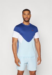 Herren Sportshirt mit einem Farbblockdesign in Blau und Hellblau, runder Ausschnitt und kurzen Ärmeln. Logo auf der oberen linken Brustseite.