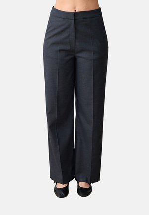 Op maat gemaakte donkergrijze wijde broek gedragen met zwarte lage hakken, weergegeven van taille tot voeten op een neutrale achtergrond.