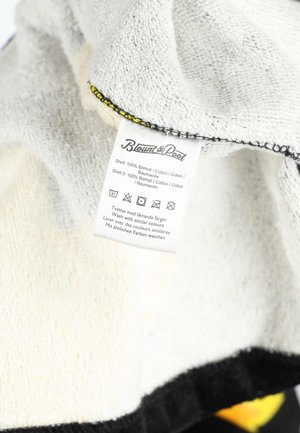 Fabric care label on soft cotton cloth showing washing instructions, material composition (100% cotton), and brand name Blount & Pool.