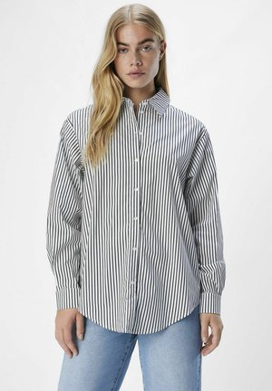 Camisa de manga larga, abotonada y con cuello, que presenta rayas verticales en blanco y negro. Está hecha de una tela ligera con una textura suave.