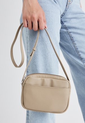 Beige Umhängetasche aus glattem Kunstleder, mit einem Reißverschluss, verstellbarem Tragegurt und einem minimalistischen rechteckigen Design.
