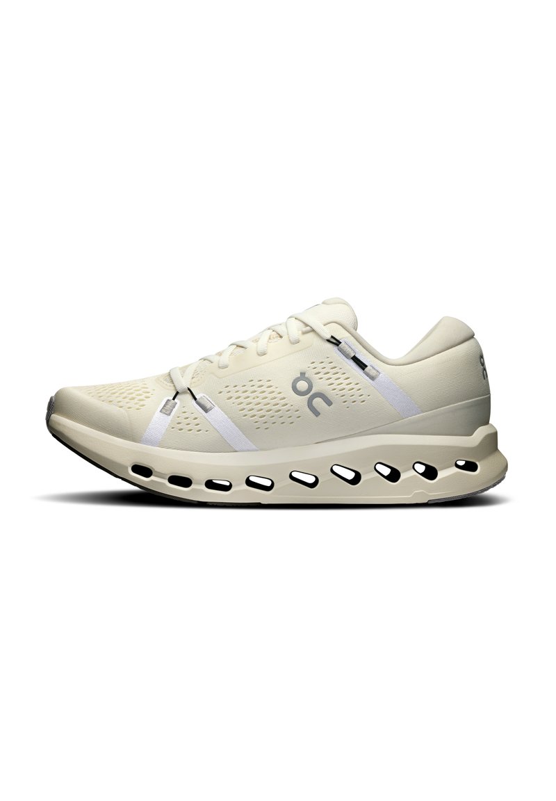 Baskets de course beiges avec une tige respirante, des accents blancs, un design léger et une semelle rembourrée avec des découpes pour la circulation de l'air.