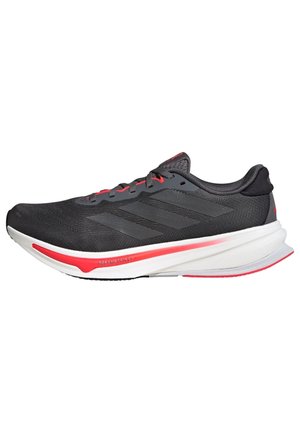 Black athletic shoe with a breathable mesh upper, grey accents, and red details. Features a cushioned sole and streamlined design for performance.