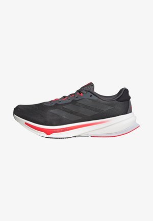 Juodas sportinis batelis su kvėpuojančiu tinkleliu, pilkais akcentais ir raudonais detalėmis. Savybės: paminkštinta padas ir aerodinamiškas dizainas, užtikrinantis našumą.