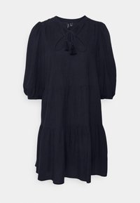 Robe bleu marine longueur genoux avec manches bouffantes, col noué, détails à pampilles et jupe à volants. Fabriquée en tissu léger avec une texture subtile.