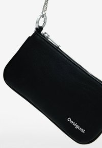 Black leather wallet with a zipper closure, silver chain, and logo detail. Smooth texture with a minimalist design.