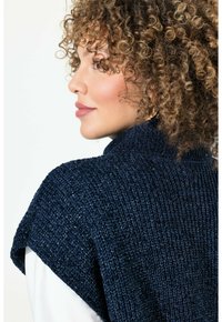 Poncho a maglia di colore blu navy con un motivo testurizzato, dotato di colletto alto e maniche larghe e aperte. Tessuto morbido con una leggera lucentezza.