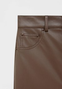 Pantalons en simili cuir marron à taille haute, avec de larges passants de ceinture et une poche unique avec des détails. La texture est lisse et brillante.
