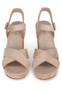 Beige suède hoge hakken sandalen met gekruiste bandjes, open neuzen, enkelband met gesp en een gematigde plateauzool voor extra hoogte.