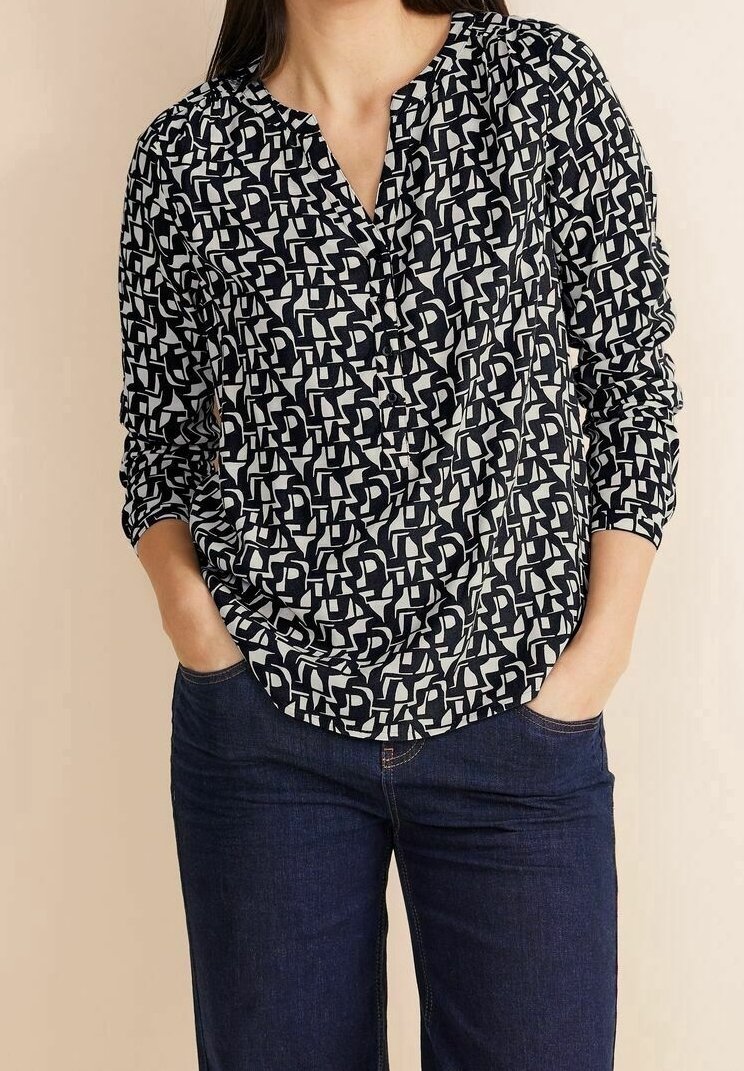 Navy und creme gemusterte Bluse mit V-Ausschnitt, langen Ärmeln und lockerer Passform, aus weichem, leichtem Stoff gefertigt.