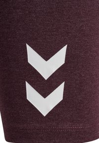 Kasztanowa tkanina z dwoma białymi pionowo nadrukowanymi, skierowanymi w dół strzałkami typu chevron, umieszczonymi w pobliżu szwu.