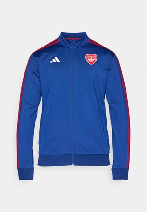 Blå polyester zip-upjakke med røde Adidas-striber. Har Arsenal-logo på brystet, høj krave og ribbede mansjetter og kant.