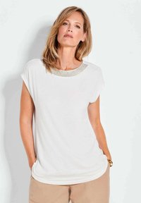 Weißes T-Shirt mit Rundhalsausschnitt und metallischen Akzenten. Weicher Stoff, lockere Passform, kurze Ärmel und abgerundeter Saum.