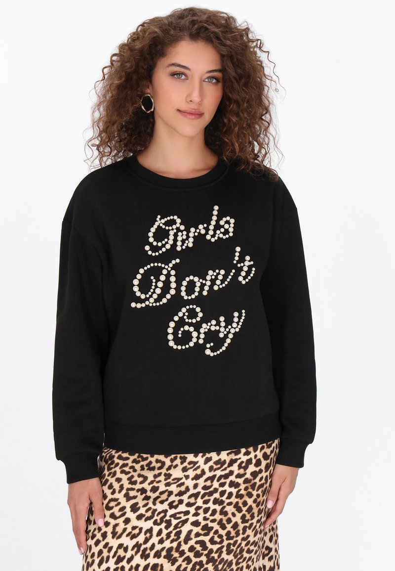 Fekete pulóver fehér gyöngydíszítéssel, amely a "Girls Don't Cry" feliratot formázza. Hosszú ujjakkal, bordázott mandzsettákkal és szegéllyel.