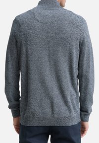 Pull-over gris avec un motif texturé, doté d'un col montant et de manches longues. Poignets et ourlet côtelés. Vue de dos présentée.