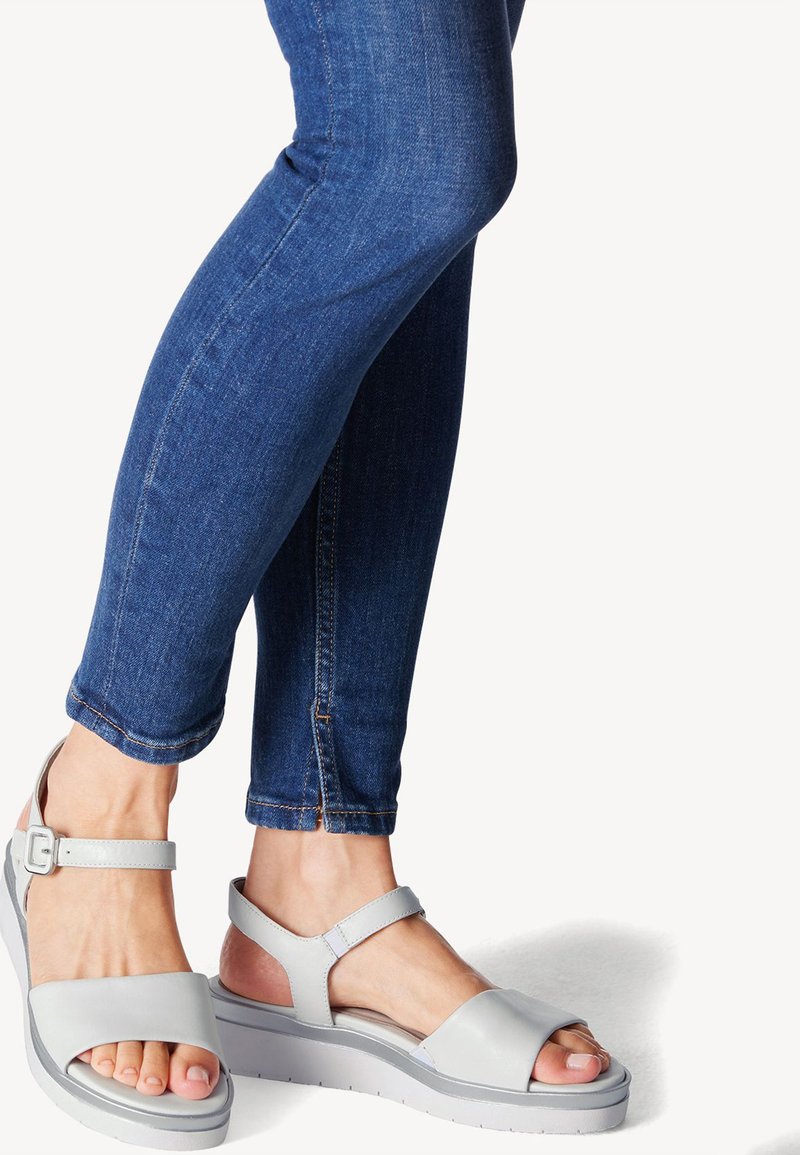 Harmaat platform-sandaalit avoimella varpaalla ja nilkkahihnalla, joissa on sileä pinta ja minimalistinen muotoilu. Yhdistetty tummansinihin slim fit -farkkuihin.