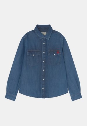Niebieska dżinsowa koszula z długimi rękawami, dwoma kieszeniami na piersi i haftowanym logo w kolorze czerwonym. Posiada klasyczny kołnierzyk i zapięcie na guziki.