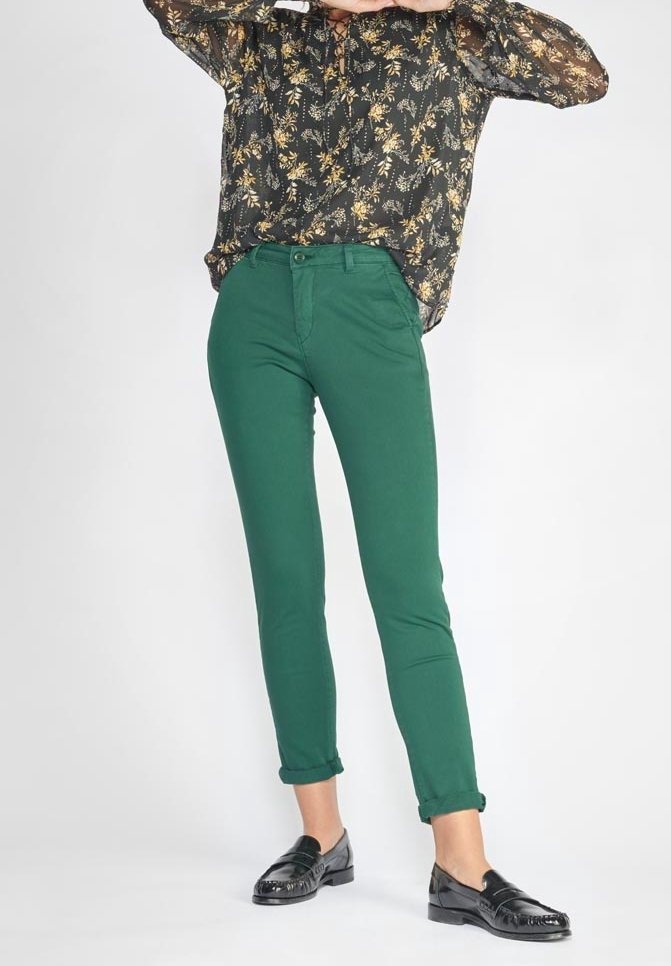 Gröna bomullshängselbyxor med slim fit, avsmalnande ben och uppvikta fållar. Bärs med en svart blommig blus och svarta loafers.