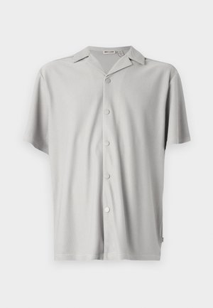 Šviesiai pilka trumpomis rankovėmis marškiniai su mygtukais, pagaminti iš raukšlėtos medžiagos, pasižymintys laisvu kirpimu, apykakle ir penkiomis metalinėmis mygtukais priekyje.