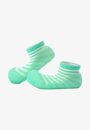 Calcetines verde menta con rayas blancas, que presentan una suela de goma flexible y redondeada. Textura suave con un diseño ceñido al tobillo para mayor comodidad.