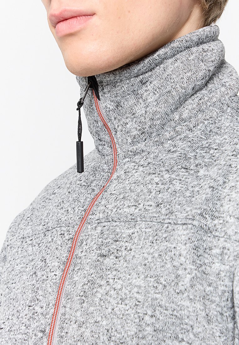 Graue Fleecejacke mit hohem Kragen, ausgestattet mit einem schwarzen Reißverschluss und orangefarbenen Nähten entlang der Vorderseite. Strukturierte Stoffoberfläche.