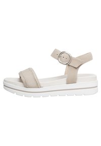 Sandalias de ante beige con suela de plataforma blanca, que cuentan con dos correas anchas y una correa ajustable en el tobillo con una hebilla de metal circular.
