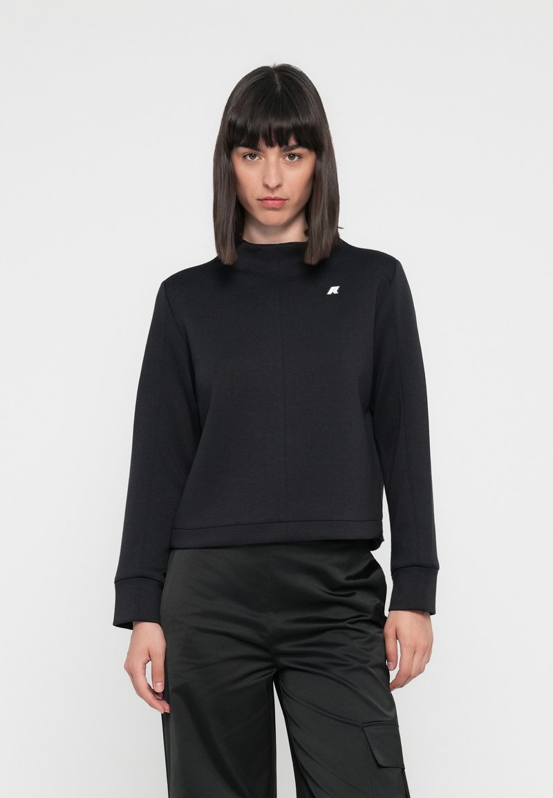 Sweatshirt noir avec un design court, des manches longues, un col rond et un petit logo blanc sur le coin supérieur gauche. Texture lisse.