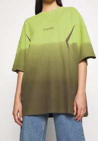 Zeleno-hnědý gradient over-sized tričko s kulatým výstřihem, krátkými rukávy a kontrastními hnědými akcenty.