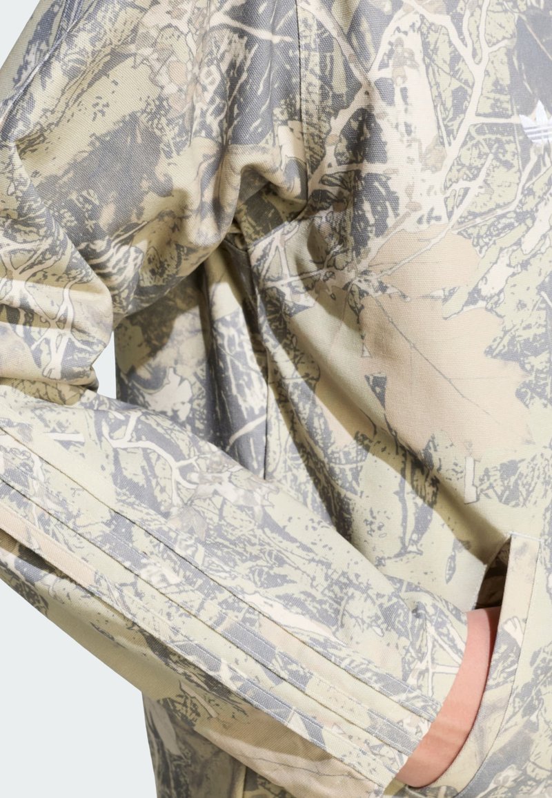 Leichtes Langarmhemd in Beige mit grauem Tarnmuster; zeichnet sich durch eine lockere Passform und dezente Nahtdetails aus.