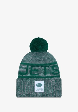 Green knit beanie with a textured pattern, featuring a fuzzy pom-pom on top and a cuff displaying the New York Jets logo and name.