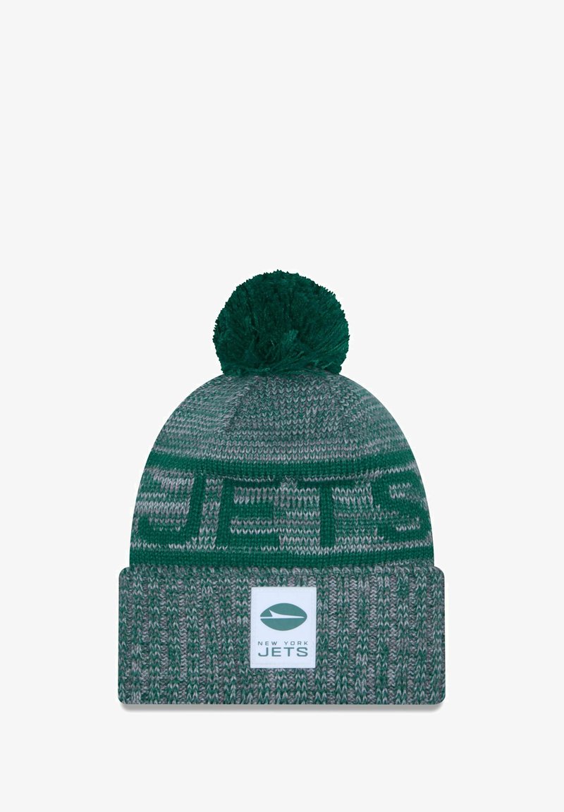 Grüner Strickmütze mit einem strukturierten Muster, ausgestattet mit einem flauschigen Pompon oben und einem Umschlag, der das Logo und den Namen der New York Jets zeigt.