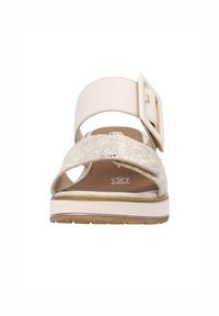 Sandale beige clair avec un dessus texturé, accent de boucle, semelle intérieure rembourrée, design à bout ouvert et semelle en caoutchouc robuste.