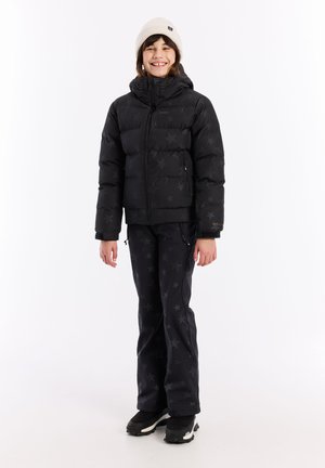 Schwarze Pufferjacke mit Sternenmuster, Reißverschluss, Kapuze und Seitentaschen, kombiniert mit passenden schwarzen Hosen im Sternenmuster und schwarzen Stiefeln.