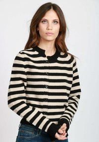 Cardigan a righe nere e beige con scollatura rotonda, chiusura a bottoni e polsini a coste. Realizzato in un morbido tessuto a maglia.