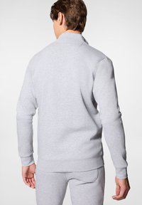 Szary sweatshirt z długimi rękawami, ściągaczami u dołu oraz detalem szwu na plecach. Gładka tekstura i dopasowany krój, idealny do codziennego użytku.