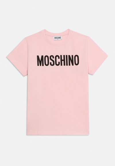 Camiseta rosa de manga corta con texto negro "MOSCHINO" en el pecho y una pequeña etiqueta de Moschino en el interior del cuello.
